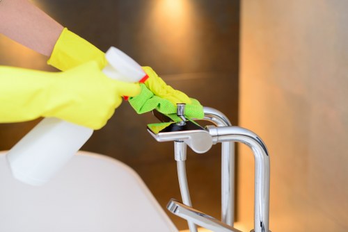 Domestic cleaner preparing a kitchen and bathroom clean in Merton
